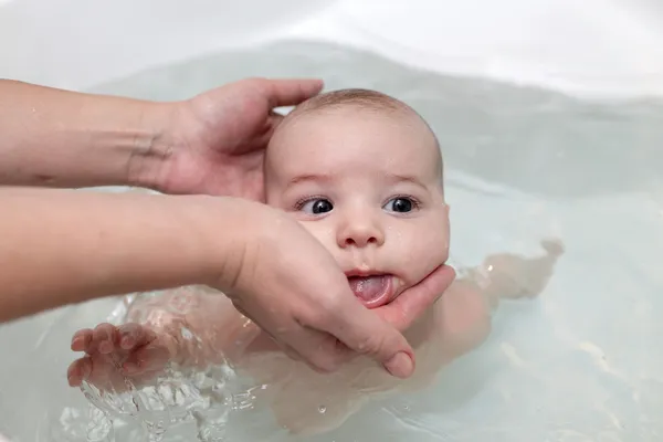 Baby boy swimming in bath — Stock Photo, Image