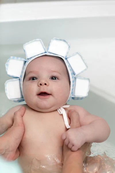 Happy baby in bath in swim cap — Stock Photo, Image