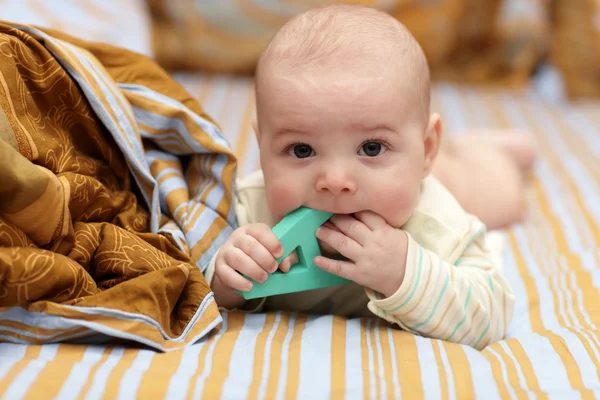 Baby biting letter — Stock Photo, Image