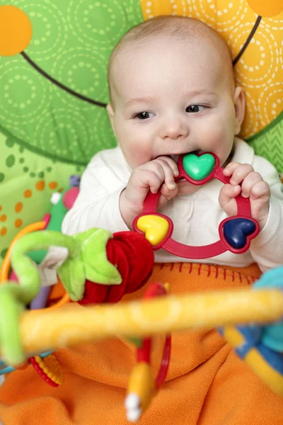 Happy baby bites rattle — Stock Photo, Image