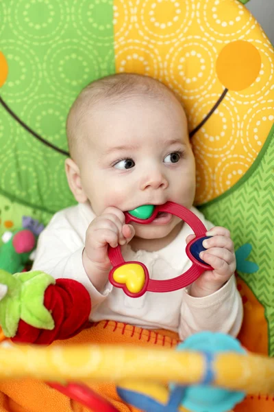 Baby boy biting rattle — Stock Photo, Image