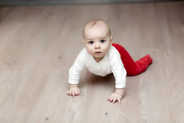 Alvorlig baby på gulvet - Stock-foto