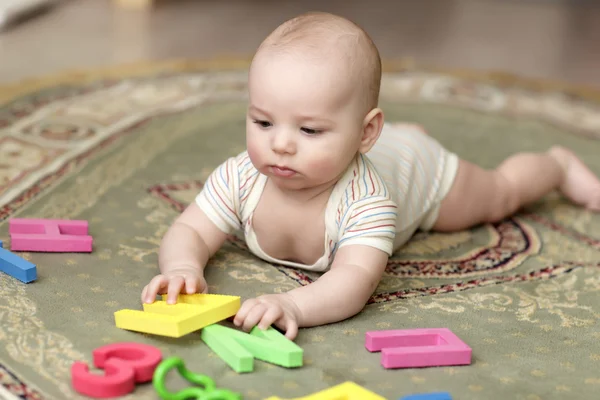 Младенец, играющий с Мбаппе — стоковое фото