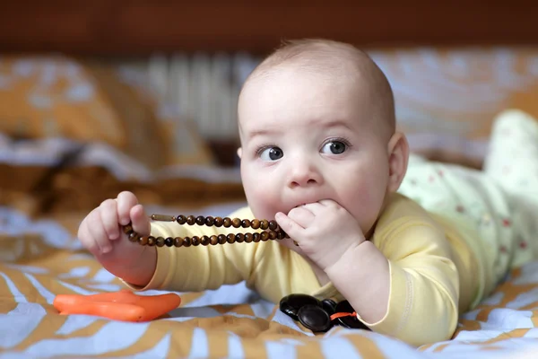 赤ちゃんのビーズをかむ — ストック写真