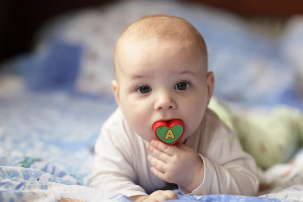 Baby beißt Kunststoffherz — Stockfoto