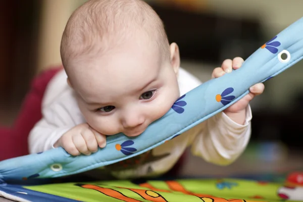 Μωρό δαγκώνει παίζοντας mat — Φωτογραφία Αρχείου