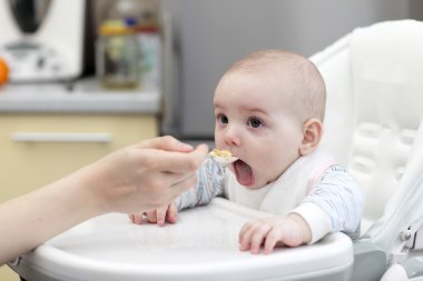 Boy eating from spoon clipart