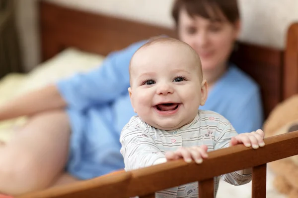 Счастливый ребенок в детской кроватке — стоковое фото