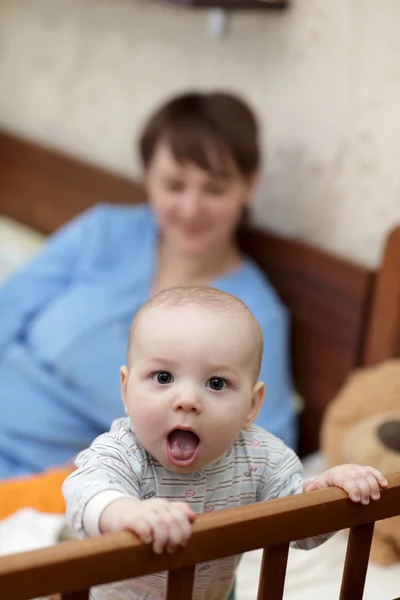 Смешной ребенок в детской кроватке — стоковое фото