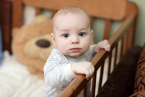 Pensive baby in cot — Stock Photo, Image