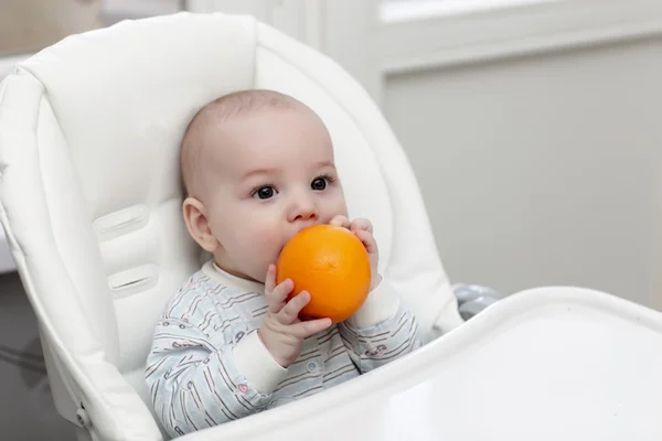 Baby biting orange — Stock Photo, Image