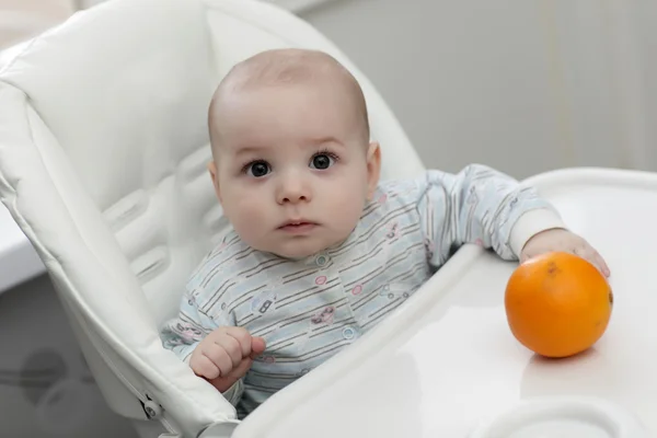 Alvorlig baby med oransje – stockfoto