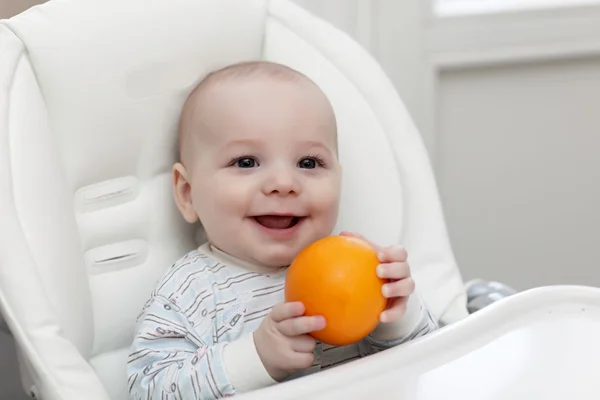 Smiling baby with orange — Stock Photo, Image