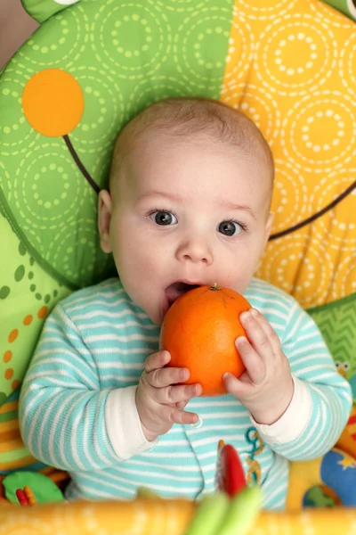 オレンジをかむ子 — ストック写真