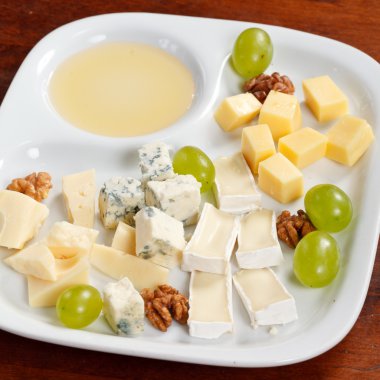 Cheese plate with grapes and honey clipart