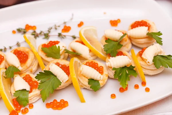 Canapes with red caviar and lemon — Stock Photo, Image