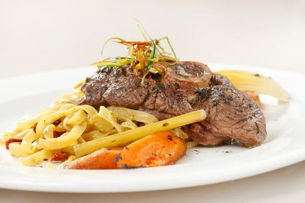 Tasty steak with pasta — Stock Photo, Image