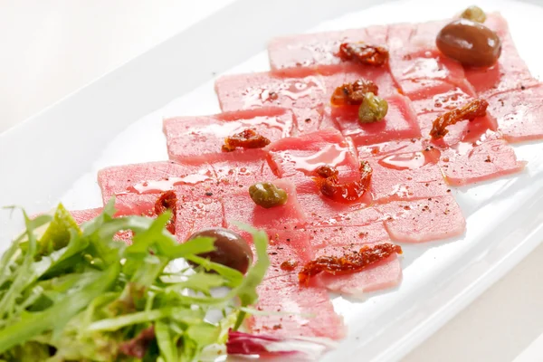 Fish Carpaccio with olives ana salad — Stock Photo, Image