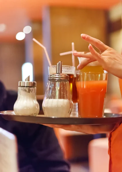 Cameriera che tiene un vassoio con gli occhiali al ristorante — Foto Stock