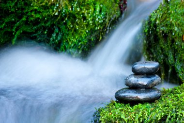 Pebble stones over waterfall clipart