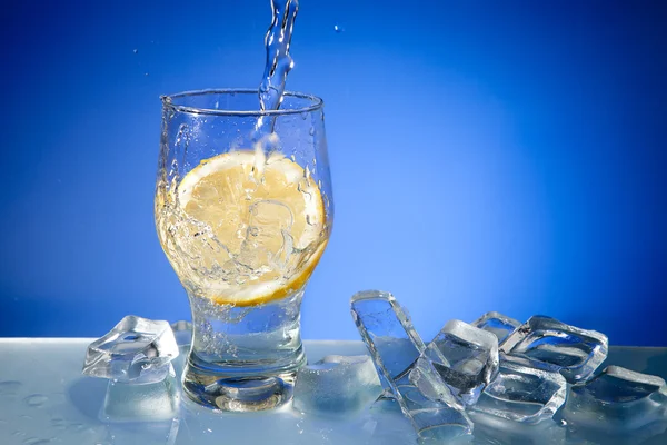 Вода, лед и лимон в стекле — стоковое фото