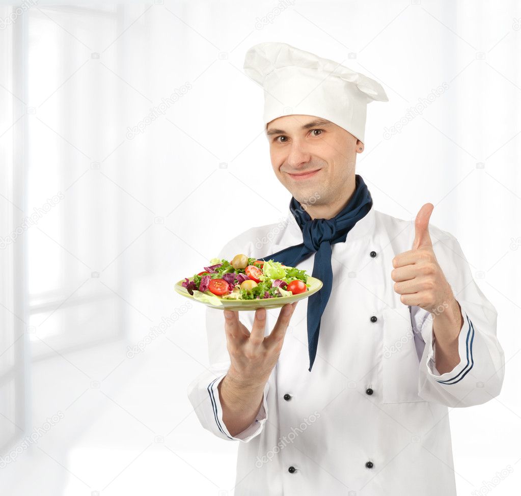 Cook man holding a plate with healthy vegetables salad