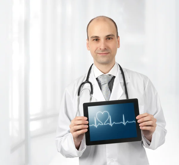 Médico sonriente con el diagrama de latidos del corazón en una tableta — Foto de Stock