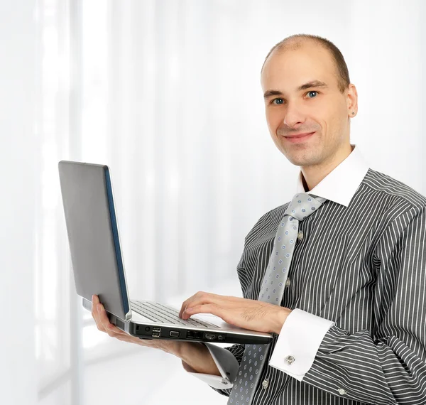 Portret van een jonge vertrouwen zakenman met laptop — Stockfoto