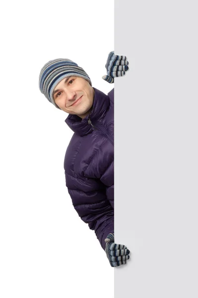 Homem em roupas de inverno exibindo um banner anúncio — Fotografia de Stock