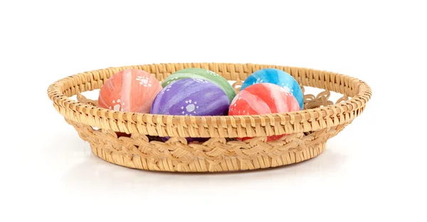 Ovos de Páscoa coloridos na cesta no fundo branco — Fotografia de Stock