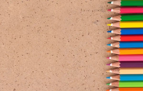 Kleur potloden op een bruine achtergrond — Stockfoto