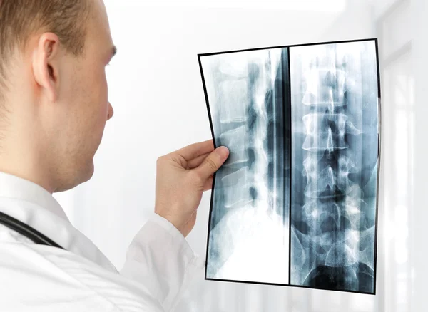 Vista posteriore del giovane medico maschio che esamina una radiografia — Foto Stock