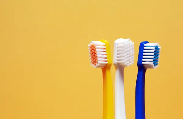 Tandenborstels op geel — Stockfoto