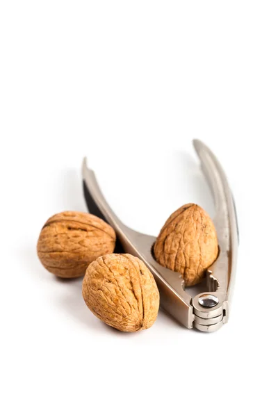 Three walnuts and nutcracker — Stock Photo, Image