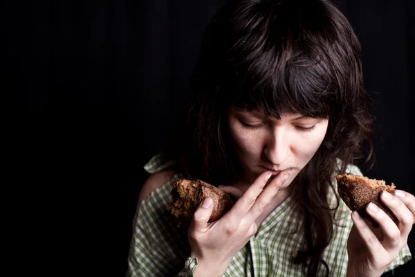 Mulher mendigo comendo pão — Fotografia de Stock