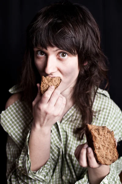 Beggar woman eating bread — Stock Photo, Image
