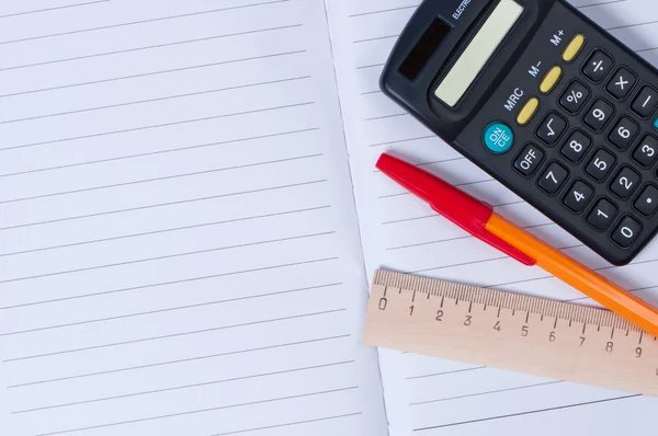 Stift, Taschenrechner und Lineal auf dem Notizbuch. — Stockfoto