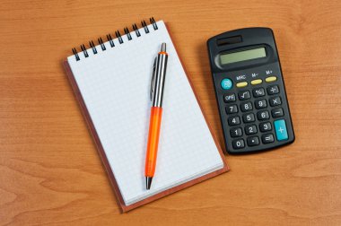 Notepad, calculator and pen on the table. clipart