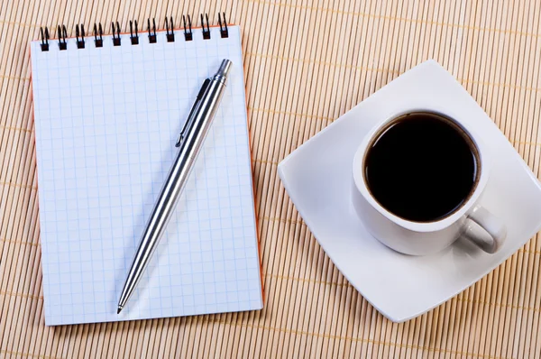 Kalem ve fincan kahve ile not etmek. — Stok fotoğraf