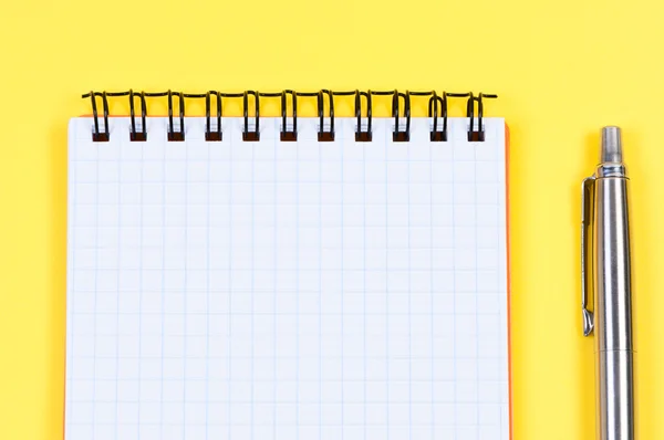 Cuaderno y bolígrafo sobre fondo amarillo . —  Fotos de Stock