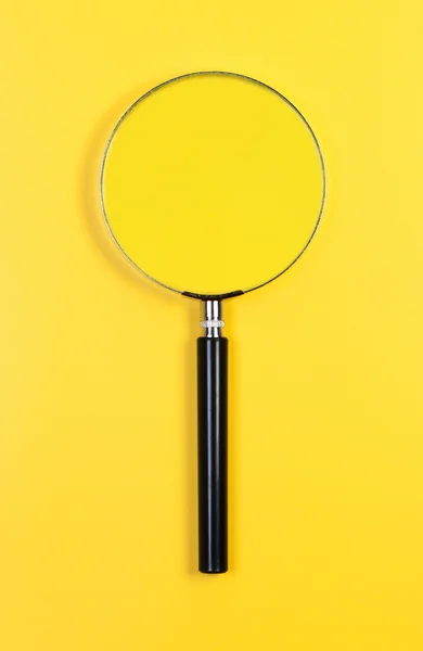 Vergrootglas op gele achtergrond. — Stockfoto