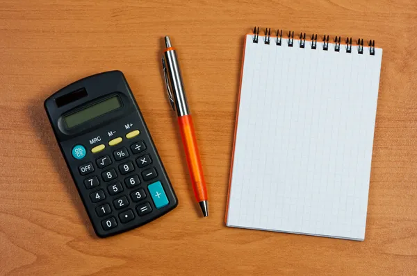 Kalkulačka, Poznámkový blok a pero na stůl. — Stock fotografie