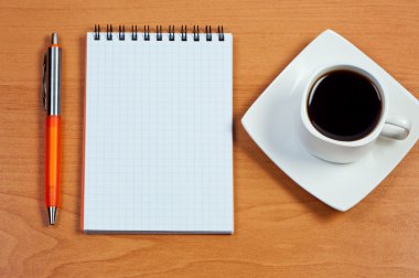 Pen, notebook and cup coffee on table. View from above. clipart