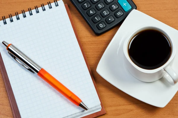 Café, bloc de notas con pluma y calculadora en la mesa de trabajo . —  Fotos de Stock