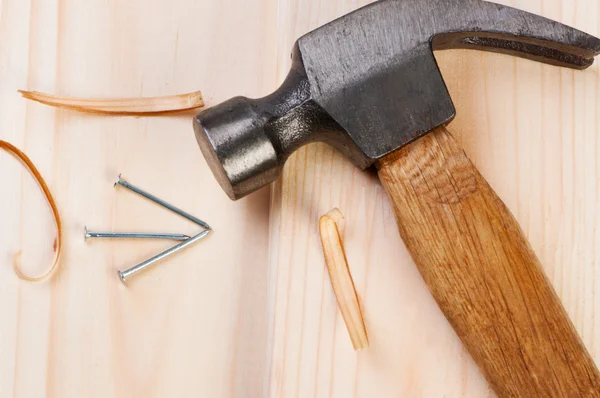 Hammer und Nagel auf Holzbrettern. — Stockfoto
