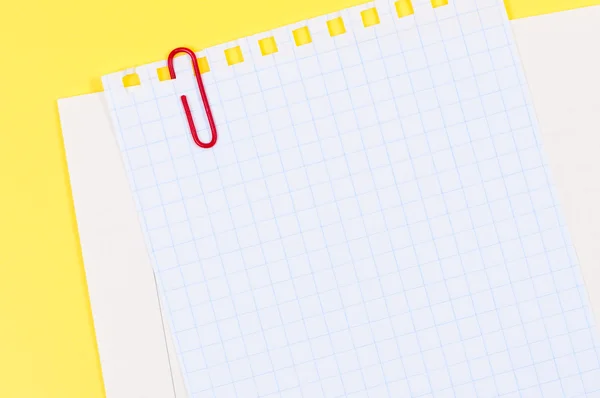 Blatt Papier mit Büroklammer auf leuchtend gelbem Hintergrund. — Stockfoto