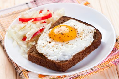 dilim ekmek üzerinde sahanda yumurta.