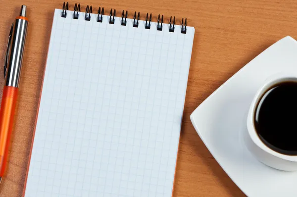 Σημειωματάριο και στυλό στο τραπέζι. διάλειμμα για καφέ. — Φωτογραφία Αρχείου