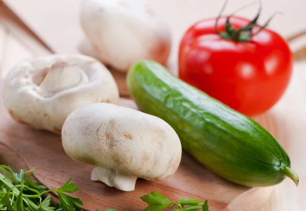 Svamp och grönsaker på skärbräda. — Stockfoto