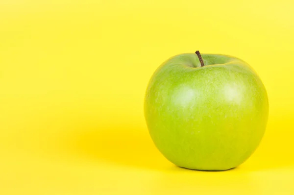 Apfel auf gelbem Hintergrund. — Stockfoto